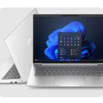 Silver HP laptop open with Windows 11 start menu and another laptop showing its back logo behind it.